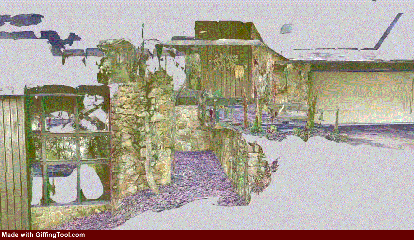 Ruined stone wall with arches and moss in foreground, distant small modern building, cool gray-green tones under a pale sky.